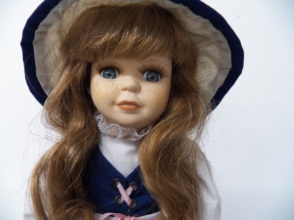 muñeca de porcelana con sombrero