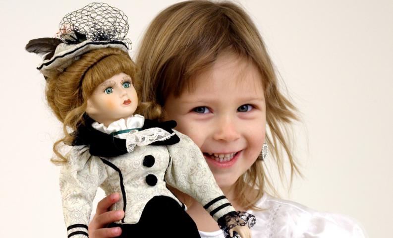 niña con muñeca de porcelana